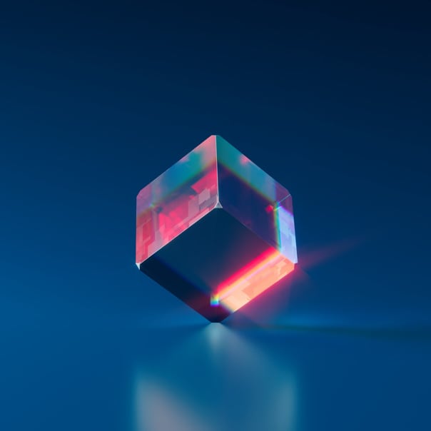 Transparent cube with red highlights resting on its corner in a dark blue background.